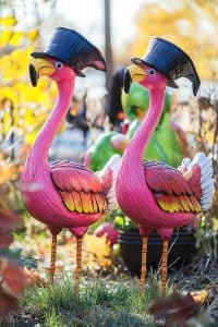 Two pink flamingos in top hats strut through autumn leaves like they own the place. Who says yard decor can't be fancy and fabulously weird?
