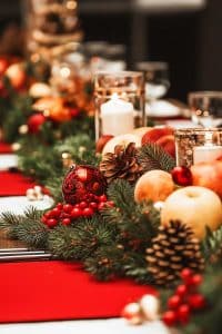 Think pine cones, red ornaments, apples, and evergreen branches sharing festive gossip around candlelight. Your holiday table just went full-on winter wonderland.