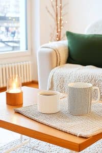 Two mugs and a candle set the scene—perfect for pretending you read that book by the cozy chair. Bonus: the window's great for daydreaming about more coffee.