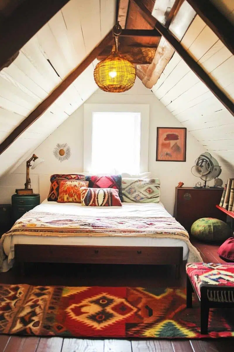 Welcome to the attic oasis: a boho dreamland where colorful pillows and a snazzy rug team up to distract you from the lamp that thinks it's a basket.