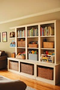 attractive_toy_storage_living_room (27) Behold, the bookshelf—a multitasking genius flaunting organized books, chic baskets, and rebellious toys daring you to stay tidy in a cozy hardwood-floored oasis.