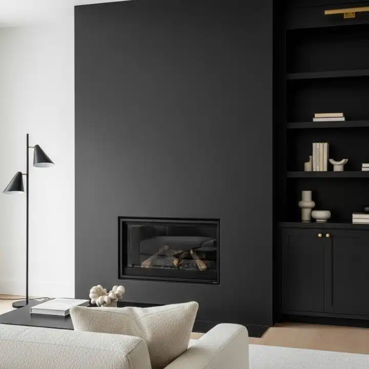 This living room rocks a moody black fireplace, shelves that beg for clutter, and a white sofa just waiting for someone to spill coffee.